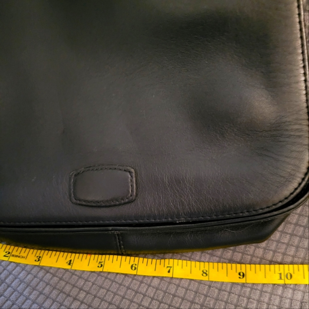 Black "saddle-bag" style shoulder bag. Magnetic snap closure.